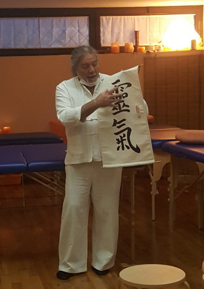Un maestro UNIPOPOLI mostra il kanji Reiki durante un seminario